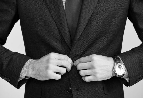 cropped man in formal suit with luxury wristwatch.
