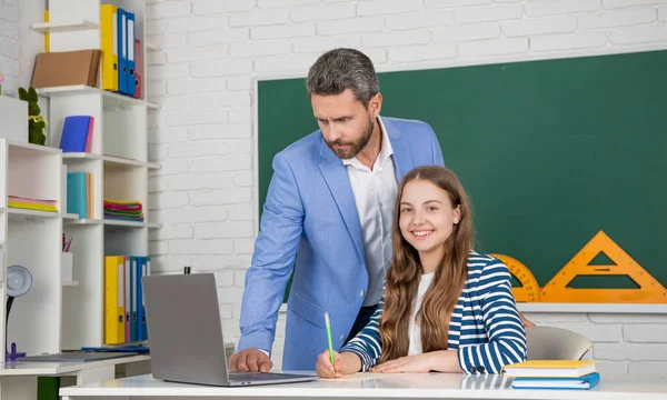 在教室里和老师在一起的快乐的孩子使用笔记本电脑 — 图库照片