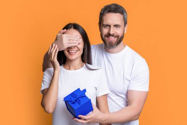 Sarı arka planda yaşayan sürpriz çift. Stüdyoda sürpriz hediyeleri olan çift. Sürpriz hediye kutusu olan tatil çifti. Tatil hediyesi olan bir çiftin fotoğrafı. Kadınlar Günü.