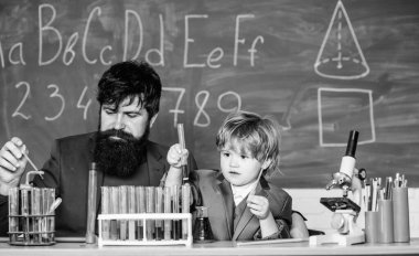 Eğitim okulu programı. Liseli çocuk sıvılarla deney yapıyor. Azim meyvesini verir. Öğretmen ve çocuk test tüpleri. Okul dersi. Kimyasal deney. Okulda dikkat eksikliği belirtileri var..