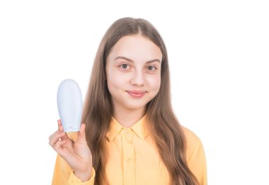 tebessüm eden çocuk şampuan ya da saç kremi şişesi sunuyor beyaz, saç bakımına izole edilmiş..