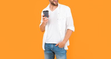 Kahve fincanıyla doğranmış mutlu bir adam. Genç adam kahve içiyor..