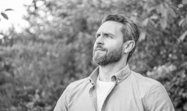 Tıraşsız yakışıklı bir adamın portresi doğal arka plan, kopyalama alanı..