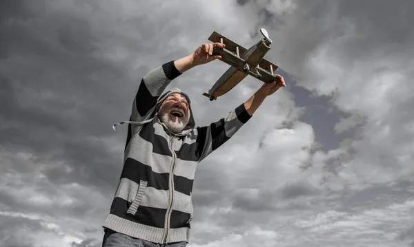 定年退職した男性です 定年退職した男だ おもちゃの飛行機の屋外で空の背景の老人 — ストック写真