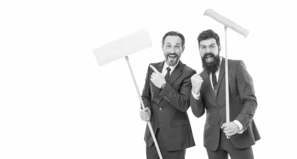 Partnership and teamwork. mature bearded men in suit hold householding mop. clean slate. businessmen clear wall to white. cleaning company. clean business. Changing responsibilities. A lot of work.