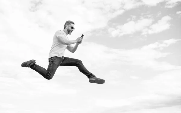 Мужчина Прыгает Болтает Смартфоне Фоне Неба Копировальное Пространство — стоковое фото