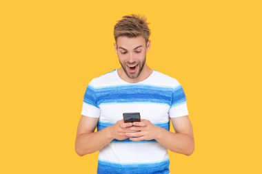 Şaşırmış adam etkili iletişim kurmak için telefonu kullanıyor. Adamın telefon bağlantısı var. Telefonlu bir adamın dijital iletişimi. Adam mesajlaşmak ya da mesajlaşmak için telefonu kullanıyor. İletişimi kolaylaştırıyor..