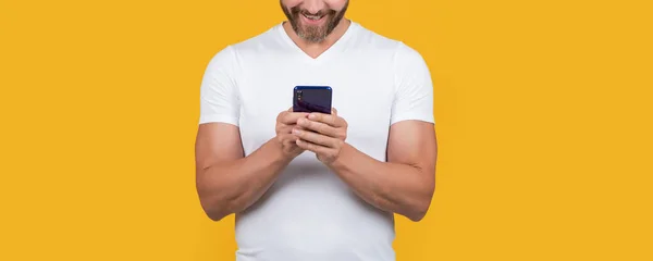 スタジオのスマートフォンで男のチャットを切り取った 男はコミュニケーションスマートフォンでチャット スマートフォンの通信チャット コミュニケーションの概念です 黄色の背景に隔離されたスマートフォンでチャットする男 — ストック写真