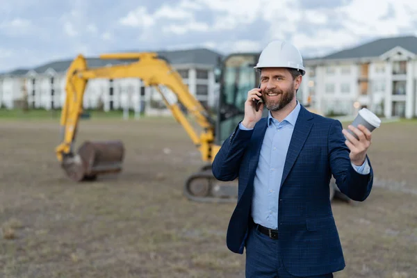 photo of smiling businessman construction investor at site with phone.