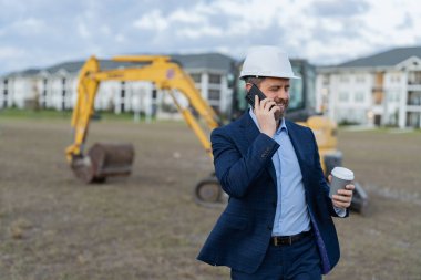 Kahve molasında iş adamı yatırımcısı olmaktan memnunum. İş adamı inşaat yatırımcısı. İş adamının inşaat yatırımcısının fotoğrafı. Telefonu olan iş adamı inşaat yatırımcısı.