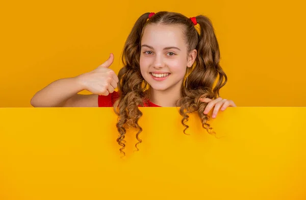 Wesoły Dzieciak Pustym Żółtym Papierem Miejscem Reklamę Kciuk Górę — Zdjęcie stockowe