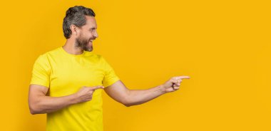 Mutlu adamın reklam teklifine işaret ettiği bir fotoğraf. Reklam teklifine işaret eden adam sarı üzerine izole edilmiş. Adam arka plandaki reklam teklifini işaret ediyor. Adam reklam teklifini işaret ediyor.