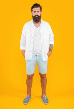 Stüdyoda şık bir beyaz adam var. Arka planda şık bir beyaz adam. Beyaz adamın yaz modası giymiş şık bir fotoğrafı. Sarıda izole edilmiş modaya uygun beyaz adam..