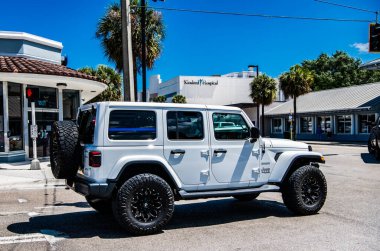 Miami, Florida ABD - 25 Mart 2023: beyaz 2018 Jeep Wrangler Sınırsız Sahra arabası yolda, arka köşe manzaralı.