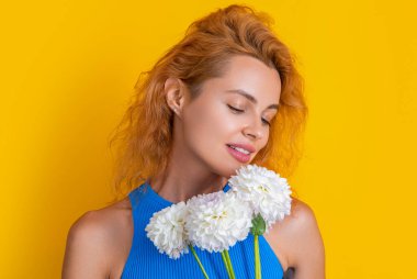Stüdyoda yaz çiçeğiyle neşeli bahar kadını. Arka planda yaz buketi olan bahar kadını. Bahar kadınının yaz çiçekli fotoğrafı. Yaz çiçekli bahar kadını sarıda izole edilmiş..