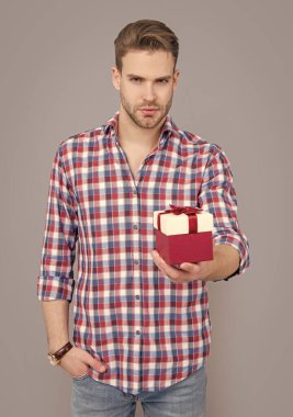 Şu anki satış konsepti. Satıştaki adam gri arka planda izole edilmiş. Stüdyoda erkek için hediye satışı. Erkek için doğum günü hediyesi. satış ve indirim.