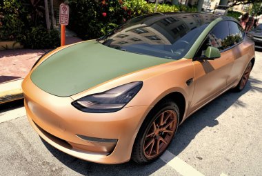 Miami Beach, Florida USA - 14 Nisan 2021: Tesla model turuncu mat 2019, yan köşe manzaralı. elektrik geçişi.
