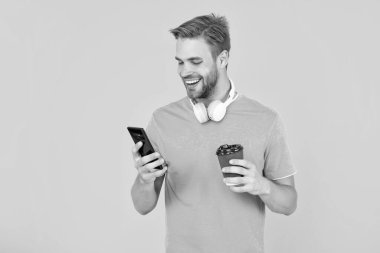 Daktilo ve mesaj. SMS ve e-postaları kontrol et. Gülümseyen adam internette kahveyle sohbet ediyor. Modern iletişim teknolojisi olarak blog yazma. Blogcu akıllı telefon kullanıyor. İnternette çalışan adam.