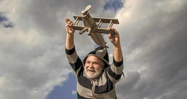 stock image happy retirement. positive granddad with toy. retired old man outdoor. senior man at retirement on sky background.