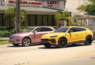 Miami Beach, Florida ABD - 15 Nisan 2021 Bentley Bentayga v8 2015 ve Giallo Auge Lamborghini Urus.