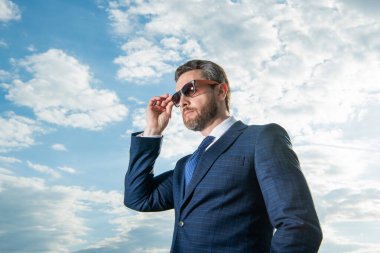 Dışarıdaki takım elbiseli CEO. Takım elbiseli CEO. Takım elbiseli CEO 'nun fotoğrafı. Gökyüzü arka planında takım elbiseli CEO..