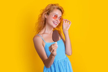 Stüdyoda dondurmalı pozitif kadın. Arkasında dondurma olan bir kadın. Yazın dondurmalı bir kadının fotoğrafı. Dondurmalı kadın sarıda izole edilmiş..