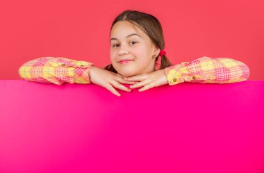 Reklam için fotokopi alanı olan boş pembe kağıdın arkasında gülümseyen çocuk..