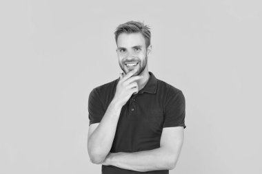 Sarı arka planda, kırmızı gömlekli mutlu, traşsız genç adam..