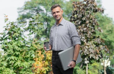 smiling man with coffee. man freelancer drink coffee outdoor. business man has coffee break.