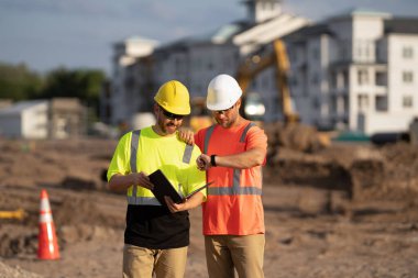 Mimarlar inşaat projesinin son teslim tarihini tartışıyor. Mimarların panolarında inşaat projesi var. İnşaat projesinde çalışan mimarların fotoğrafı. İnşaat projesinde çalışan mimarlar