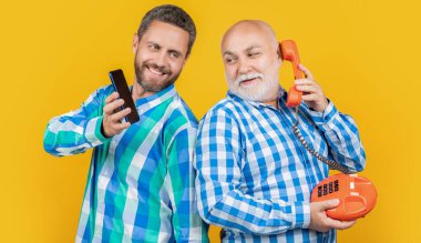 Mutlu adamlar vs teknolojisi ile sarı üzerinde izole. Stüdyoda teknolojisi olan mutlu adamlar. Arka planda teknolojisi olan erkekler. Telefon ve telefon teknolojisi olan adamların fotoğrafları..