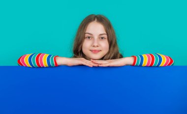 Boş mavi kağıtlı gülümseyen çocuk reklam için fotokopi alanı ile.