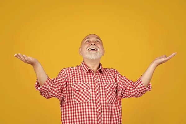 stock image positive senior man or grandfather in checkered shirt on yellow background.