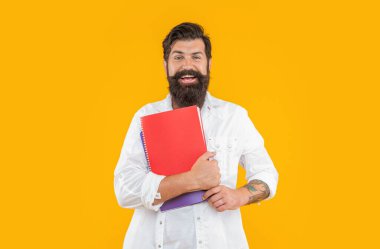 Sırıtkan milenyum adamı planlayıcısı sarıda soyutlanmış. Stüdyoda planlayıcısı olan bin yıllık bir adam. Arkaplanda planlayıcısı olan bin yıllık bir adam. Ajandalı milenyum adamının fotoğrafı..