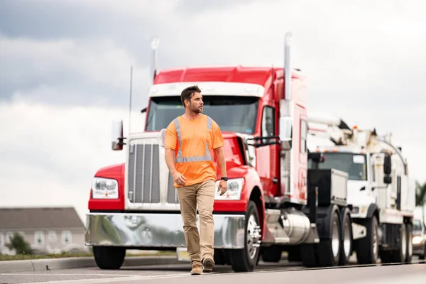 stock image Highway engineer walking on highway. Man wearing orange safety vest for traffic work. Highway engineering. Highway transport and transportation.