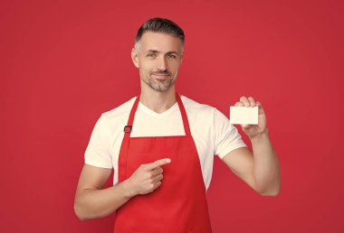 Üzerinde fotokopi alanı olan önlüklü olgun bir adam. işaret parmağı.