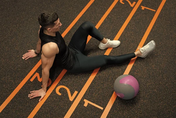 适合男人坐在健身房的地板上 健美操结束后 运动员在体育馆休息 健身体操训练 健康与锻炼 — 图库照片