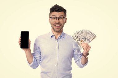 Happy man showing cash money and smartphone studio. Cash payment or smartphone payment. Cash purchase. Paying in cash for smartphone.