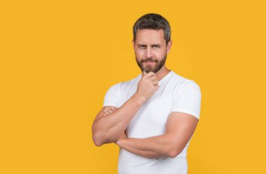 Stüdyoda sıradan gülümseyen adam. Beyaz gömlek giyen beyaz bir adamın fotoğrafı. Sıradan giyinen bir adam. Sıradan gömlekli sakallı adam sarı arka planda izole edilmiş..