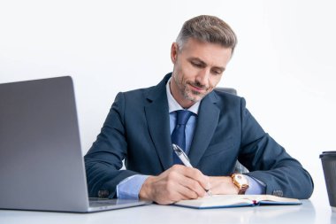 Olgun girişimci, iş ofisindeki masada yazı yazıyor..