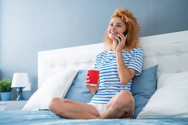 Kahveli kadının telefonla araması güzel. Evdeki kadının telefonu var. Kadının evine telefon var..