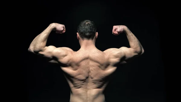 ボディビルダーの男の筋肉を黒で隔離した 体を作る男の筋肉をスタジオに戻す 背景にボディビルダーの男の筋肉バック ボディビルダーの男性の筋肉を — ストック写真