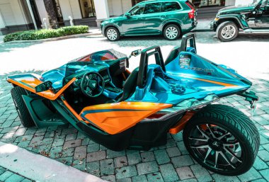 Miami Beach, Florida USA - April 15, 2021: blue orange polaris slingshot, back corner view. three-wheeled motorcycle.