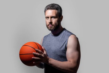 Gri arka planda izole edilmiş atlet basketbolcu. Atlet basketbolcu stüdyoda. Basketbolcu bir sporcunun fotoğrafı. Spor giyim sektöründe basketbolcu..