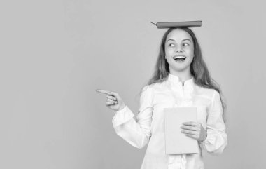 Kitabı fotokopi alanını gösteren mutlu çocuk. Okula dönüyorum. Çocukluk eğitimi. Bilgi günü. Çocuk defteri tut. Lise öğrencisiydim. Genç kız ödevlerini defter ile yapıyor..