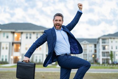 Açık havada başarılı bir emlak işçisi. Gayrimenkul işadamının fotoğrafı. Emlakçı. Evrak çantalı emlakçı..