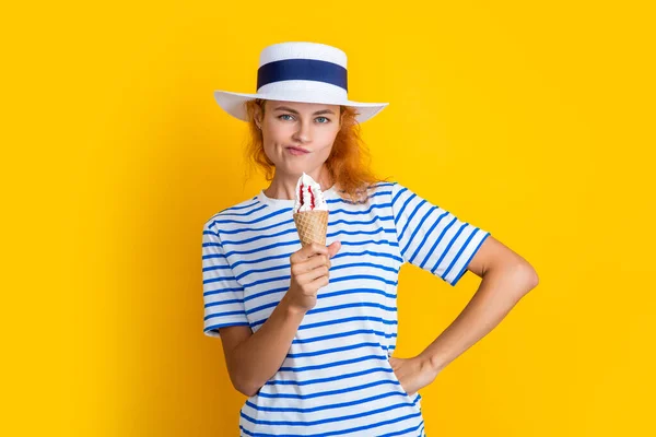 thoughtful summer woman with sweet cone in retro hat. summer woman with sweet cone isolated on yellow. summer woman with sweet cone in studio. summer woman with sweet cone on background.