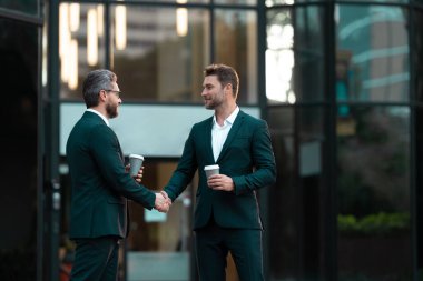 two business partners hold coffee dealing negotiation, copy space. photo of two business partners dealing negotiation. two business partners dealing negotiation. two business partners dealing clipart