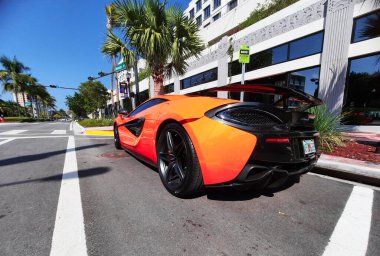 Los Angeles, Kaliforniya ABD - 24 Mart 2021: Turuncu McLaren Otomotiv Limited 570 'ler lüks spor araba arka köşe manzarası.