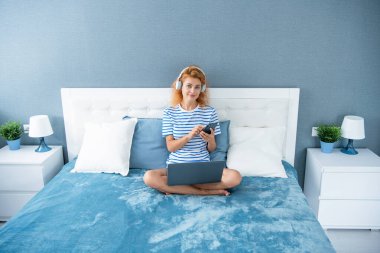 Telefondaki kadın sohbeti. Kadın evde telefonla konuşurken gülümsüyor. Kulaklıklı kadının telefon görüşmesi..